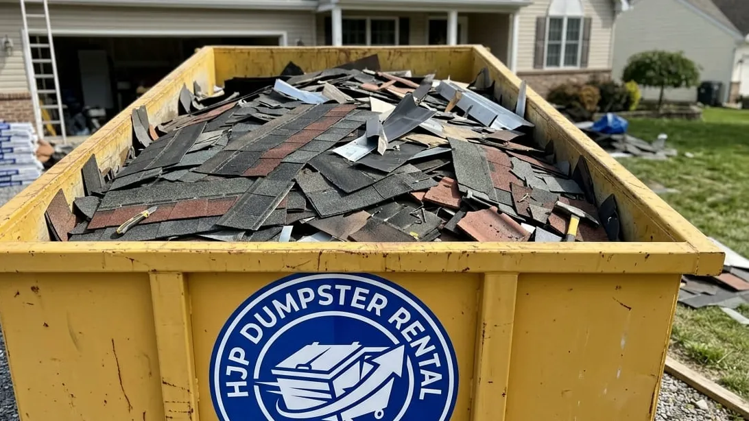 Hail damage roof tear-off dumpsters in Kelim, Colorado — shingle loaded flat by weight after a Front Range hailstorm